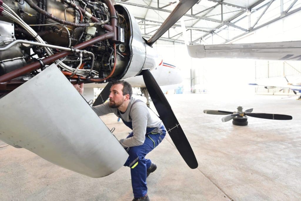 Aircraft technician inspecting engine for corrosion