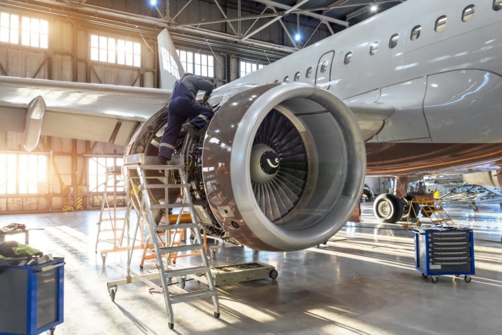 Aircraft technician working on an engine in a hangar