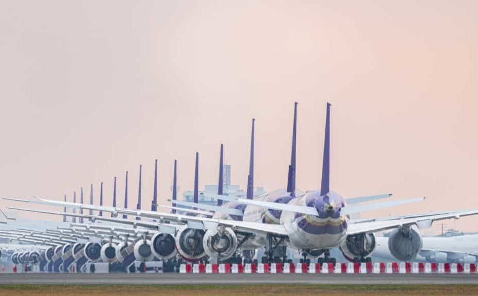 Fleet of commercial aircraft on an airport runway.