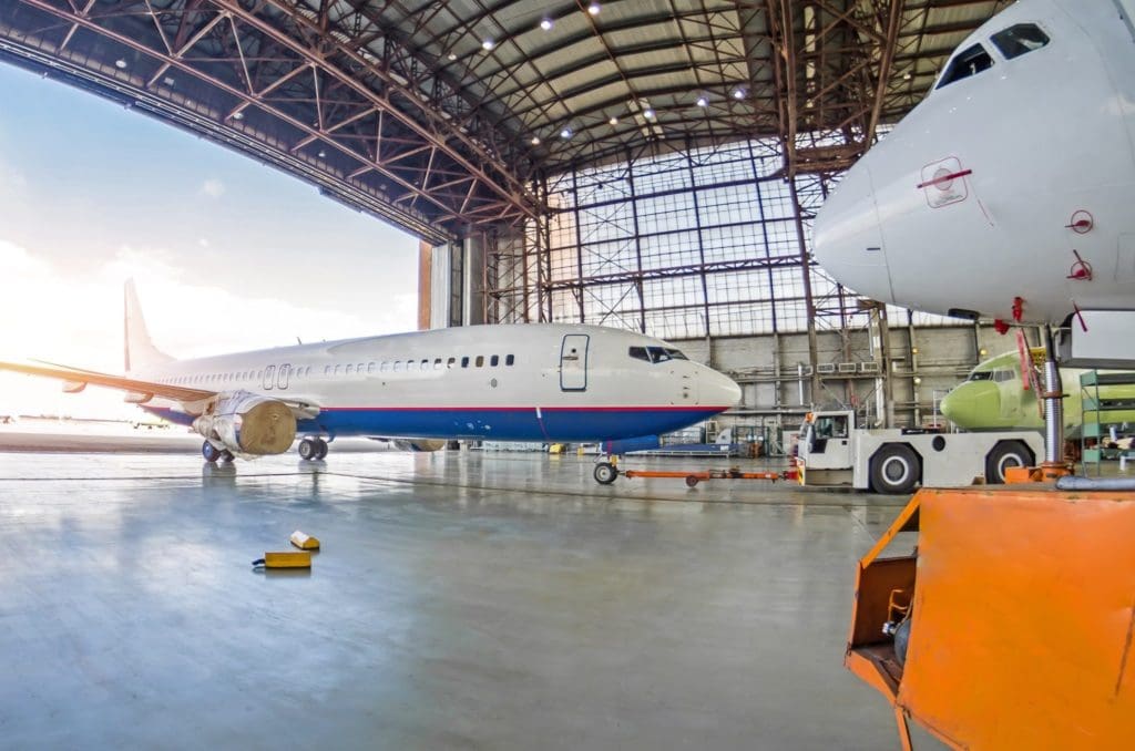 Commercial aircraft being towed into hangar for repair